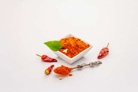 Hungarian hot paprika powder isolated on white background. Traditional seasoning in ceramic plate