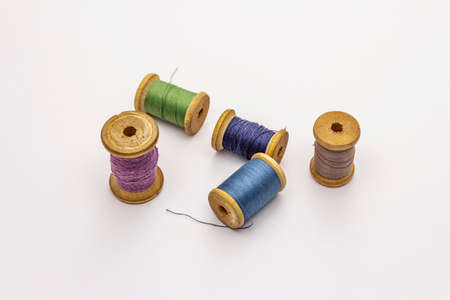 Colorful wooden spools of thread isolated on white background. Tool for sewing, handmade, craft, profession. Needlework, DIY conceptの写真素材
