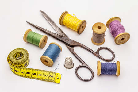 Old vintage scissors and spools of thread isolated on white background. Tool for sewing, handmade,...