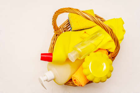 House cleaning product in basket. Spray, bottle, soap, dishwashing sponge, duster, gel air freshener. Home disinfection in quarantine. White putty backgroundの写真素材