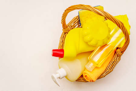 House cleaning product in basket. Spray, bottle, soap, dishwashing sponge, duster, gel air freshener. Home disinfection in quarantine. White putty backgroundの写真素材