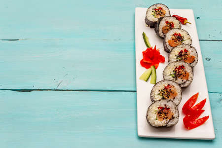 Korean roll Gimbap(kimbob). Steamed white rice (bap) and various other ingredients. Trendy turquoise wooden boards backgroundの写真素材
