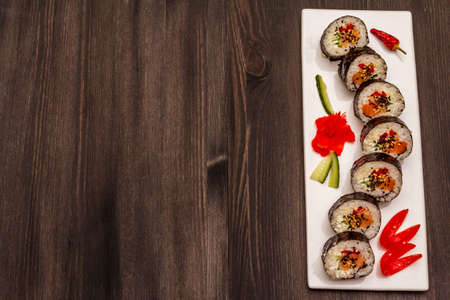 Korean roll Gimbap(kimbob). Steamed white rice (bap) and various other ingredients. Trendy black wooden boards backgroundの写真素材