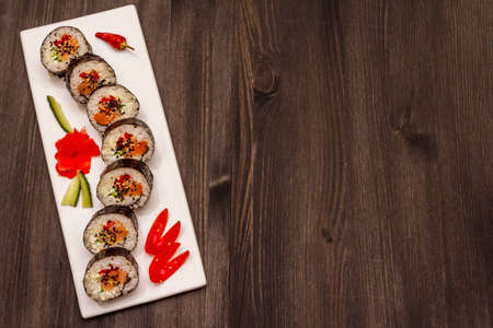 Korean roll Gimbap(kimbob). Steamed white rice (bap) and various other ingredients. Trendy black wooden boards backgroundの写真素材