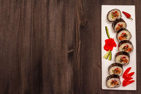 Korean roll Gimbap(kimbob). Steamed white rice (bap) and various other ingredients. Trendy black wooden boards backgroundの写真素材