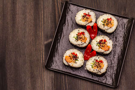 Korean roll Gimbap(kimbob). Steamed white rice (bap) and various other ingredients. Trendy black wooden boards backgroundの写真素材