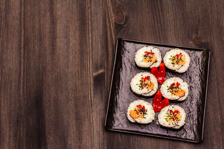 Korean roll Gimbap(kimbob). Steamed white rice (bap) and various other ingredients. Trendy black wooden boards backgroundの写真素材