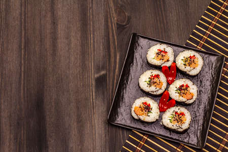 Korean roll Gimbap(kimbob). Steamed white rice (bap) and various other ingredients. Trendy black wooden boards backgroundの写真素材