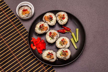 Korean roll Gimbap(kimbob). Steamed white rice (bap) and various other ingredients. Trendy black stone concrete backgroundの写真素材