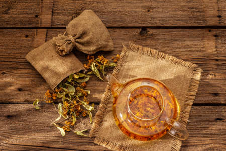 Linden tea. Dry fragrant flowers. Sunny morning breakfast. Hot drink to strengthen the immune system, alternative medicine. Vintage wooden tableの写真素材