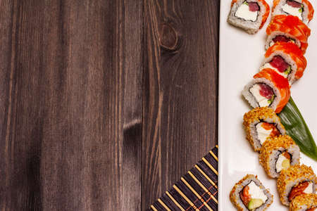 Assorted sushi set. Japanese or Korean roll with different fresh ingredients. Trendy black wooden boards backgroundの写真素材