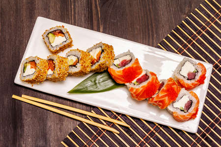 Assorted sushi set. Japanese or Korean roll with different fresh ingredients. Trendy black wooden boards backgroundの写真素材