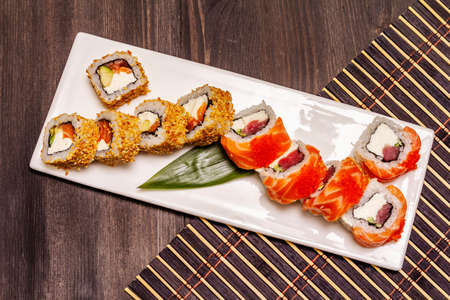 Assorted sushi set. Japanese or Korean roll with different fresh ingredients. Trendy black wooden boards backgroundの写真素材