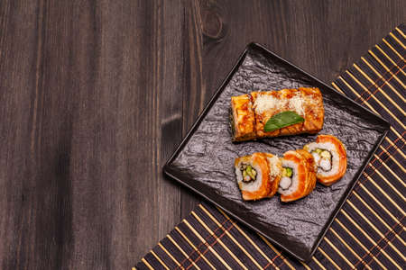Grilled tiger prawn sushi. Japanese or Korean roll with different fresh ingredients. Trendy black wooden boards backgroundの写真素材