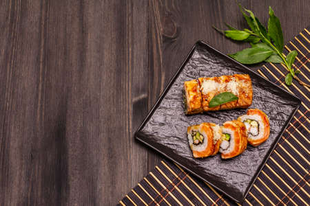 Grilled tiger prawn sushi. Japanese or Korean roll with different fresh ingredients. Trendy black wooden boards backgroundの写真素材