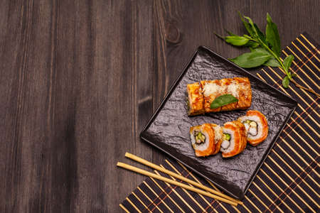 Grilled tiger prawn sushi. Japanese or Korean roll with different fresh ingredients. Trendy black wooden boards backgroundの写真素材