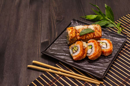 Grilled tiger prawn sushi. Japanese or Korean roll with different fresh ingredients. Trendy black wooden boards backgroundの写真素材
