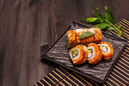 Grilled tiger prawn sushi. Japanese or Korean roll with different fresh ingredients. Trendy black wooden boards backgroundの写真素材