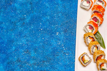 Assorted sushi set. Japanese or Korean roll with different fresh ingredients. Nautical blue backgroundの写真素材