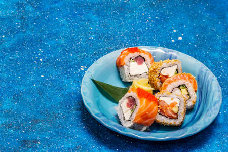 Assorted sushi set. Japanese or Korean roll with different fresh ingredients. Nautical blue backgroundの写真素材