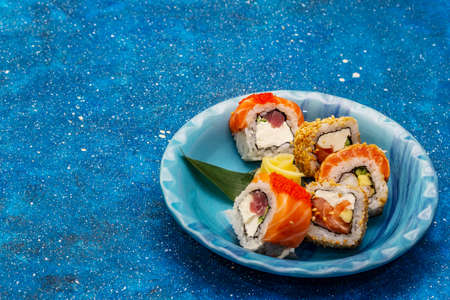 Assorted sushi set. Japanese or Korean roll with different fresh ingredients. Nautical blue backgroundの写真素材