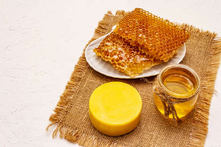 Spa concept. Self care with honey and honeycombs. Natural organic cosmetics, homemade product, alternative lifestyle. White putty backgroundの写真素材