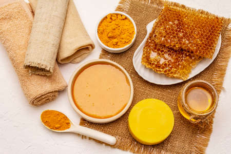 Spa concept. Self care with honey and turmeric. Natural organic cosmetics, homemade product, alternative lifestyle. White putty backgroundの写真素材