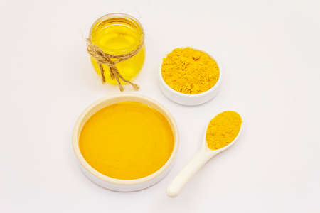 Dry turmeric powder and honey isolated on white background. Traditional Indian ingredient for more dishes and cosmeticsの写真素材