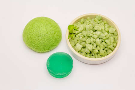 Sea salt, green tea soap and sponge isolated on white background. Spa concept, homemade cosmetics from natural ingredientの写真素材