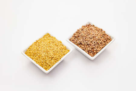 Brown and golden flax seeds isolated on white background. Trendy superfood, ingredient for making healthy foodの写真素材