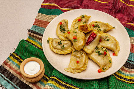 Dumplings stuffed stewed cabbage and sour cream. Traditional Ukrainian dish v-arenyky. Healthy vegan (vegetarian) food. Stone concrete backgroundの写真素材