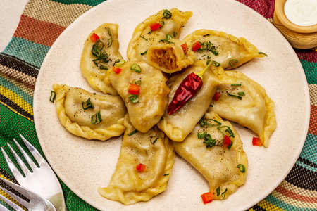 Dumplings stuffed stewed cabbage and sour cream. Traditional Ukrainian dish v-arenyky. Healthy vegan (vegetarian) food. Stone concrete backgroundの写真素材