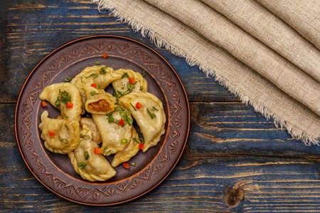 Dumplings stuffed stewed cabbage and sour cream. Traditional Ukrainian dish varenyky. Healthy vegan (vegetarian) food. Old blue wooden backgroundの写真素材