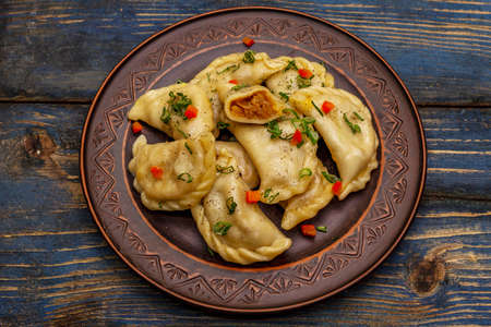 Dumplings stuffed stewed cabbage and sour cream. Traditional Ukrainian dish varenyky. Healthy vegan (vegetarian) food. Old blue wooden backgroundの写真素材