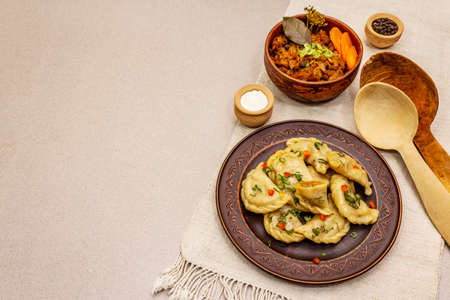 Dumplings stuffed stewed cabbage and sour cream. Traditional Ukrainian dish v-arenyky. Healthy vegan (vegetarian) food. Stone concrete backgroundの写真素材