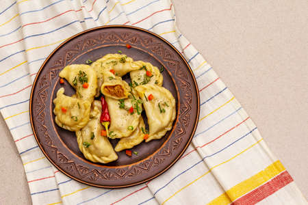 Dumplings stuffed stewed cabbage and sour cream. Traditional Ukrainian dish v-arenyky. Healthy vegan (vegetarian) food. Stone concrete backgroundの写真素材