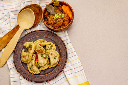 Dumplings stuffed stewed cabbage and sour cream. Traditional Ukrainian dish v-arenyky. Healthy vegan (vegetarian) food. Stone concrete backgroundの写真素材