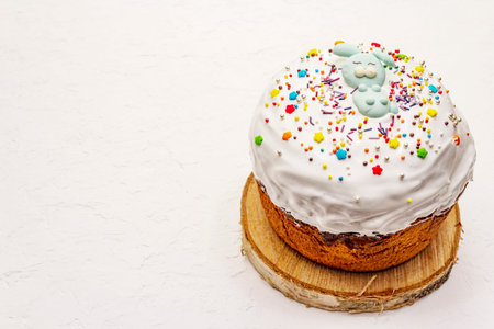 Easter cake on white putty background. Traditional Orthodox festive bread, wooden stand
