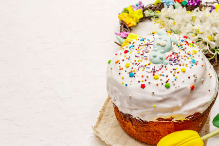 Easter cake on white putty background. Traditional Orthodox festive bread, wooden stand