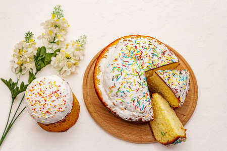 Easter cakes on white putty background. Traditional Orthodox festive bread, wooden cutting board, flowers decorの写真素材