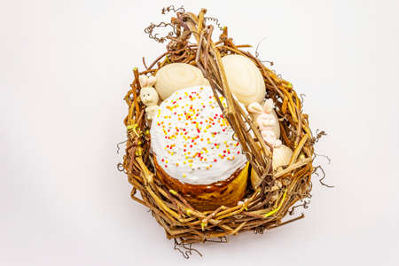 Easter cake, rabbits and eggs in wicker basket isolated on white background. Traditional Orthodox festive breadの写真素材