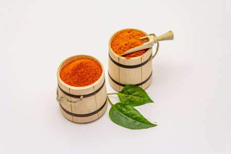 Two types of Hungarian paprika powder, hot and sweet, isolated on white background. Traditional seasoning in wooden barrelの写真素材