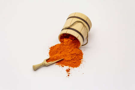 Hungarian hot paprika powder isolated on white background. Traditional seasoning in wooden barrelの写真素材