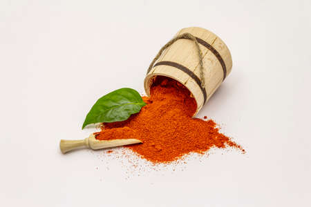 Hungarian sweet paprika powder isolated on white background. Traditional seasoning in wooden barrelの写真素材