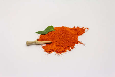 Hungarian sweet paprika powder isolated on white background. Heap of traditional seasoning, wooden scoopの写真素材