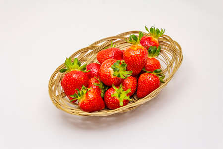 Sweet fresh strawberry isolated on white background. Ripe berries fruit in wicker basket, tasty ingredient for many dishesの写真素材