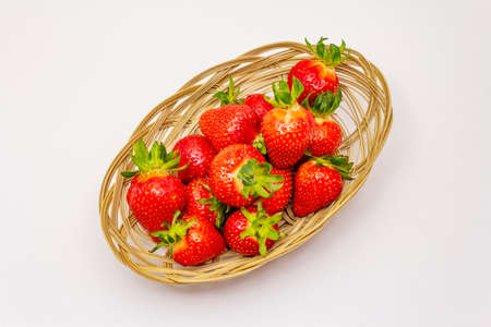 Sweet fresh strawberry isolated on white background. Ripe berries fruit in wicker basket, tasty ingredient for many dishesの写真素材