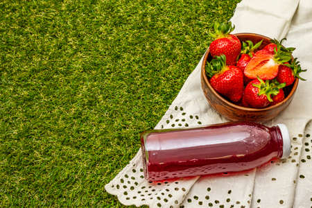 Sweet fresh strawberry and compote. Ripe berries fruit, tasty ingredient for many dishes. Artificial green grass backgroundの写真素材