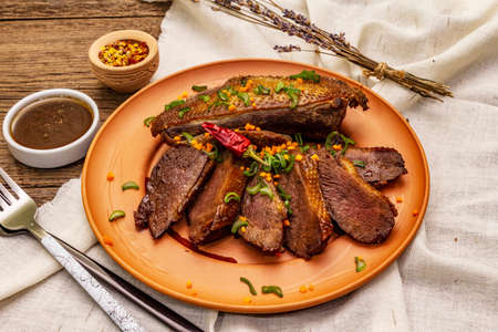 Roasted duck breasts, spices and Demi-glace sauce. Traditional French food, vintage wooden boards background, close upの写真素材