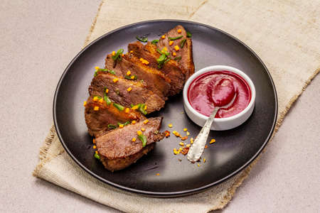 Roast and braised duck breast with sweet and sour berry sauce. Traditional French food, stone concrete background, close upの写真素材